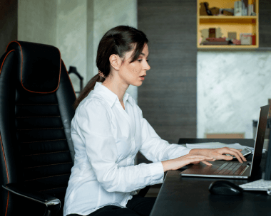 A  woman working a laptop, representing seamless delivery, accessibility, and compliance for Spanish transcription needs.